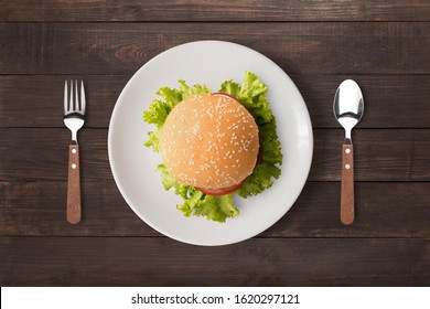 Top view BBQ burger on white dish on wooden background.