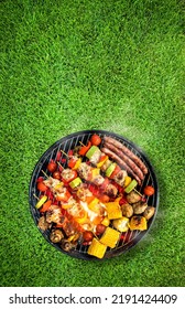 Top view of bbq grill, grilled meat, vegetables, mushrooms with flames and smoke. Placed on green grass lawn. Grilled food, vertical composition. - Shutterstock ID 2191424409