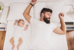Top View. Bearded Father Sleeps With Baby In Bed. Little Newborn Child In White Bed. Parenthood Concepts. Love And Happiness. Taking Care Of New Life. Family, Love, Happiness Concepts.