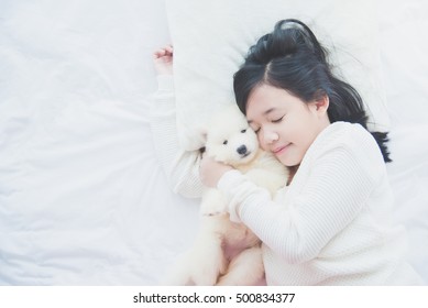 Top View Of Beautiful Asian Girl Sleeping With Siberian Husky Puppy On  White Bed