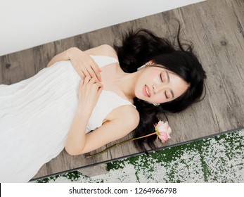 Top View Of A Beautiful Chinese Girl Laying Down On Floor With Eyes Closed, Portrait Of Romantic Young Female Has A Good Dream.