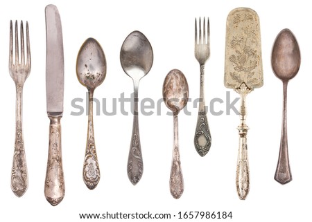 Top view of beautiful vintage silver knifes, spoons and forks  isolated on white background. Silverware. 
