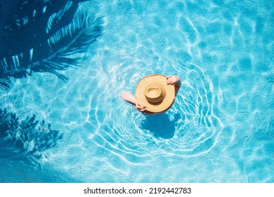Top view of beautiful woman earing sunhat relaxing in swimming pool - Shutterstock ID 2192442783