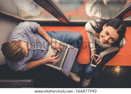 Similar – Image, Stock Photo Smiling couple using gadgets while spending time together