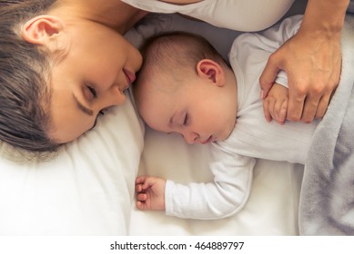 Top View Of Beautiful Young Mom And Her Cute Little Baby Sleeping In Bed At Home, Close-up