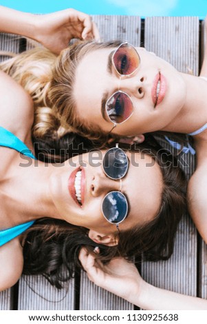 Similar – Two women with sunglasses smiling lying in blanket