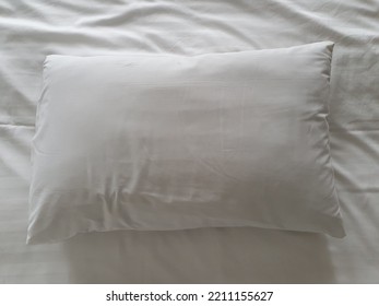 A Top View Of A Bed With Clean White Sheets And Pillow