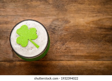 Top view of beer with clover leaf on wooden table, space for text. St Patrick's Day celebration - Powered by Shutterstock