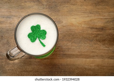 Top view of beer with clover leaf on wooden table, space for text. St Patrick's Day celebration - Powered by Shutterstock