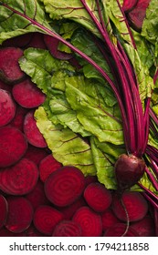 Top view of beet slices, beet leaves and one beet and beetroot for food background with copy space.