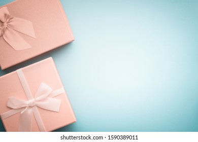 Top view beige gift boxes with ribbons tied with a bow on a light blue background in pastel colors/