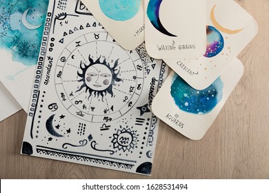 Top View Of Birth Chart And Cards With Zodiac Signs On Wooden Table