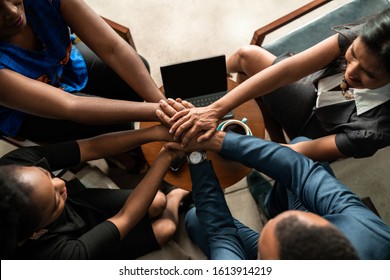 Top View Of Black African Business Team With Hands Stacked Together In Unity And Trust.