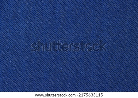 Top view of black and navy blue herringbone fabric texture background. Pattern of smooth cloth backdrop with lurex glittering metallic thread for design art work