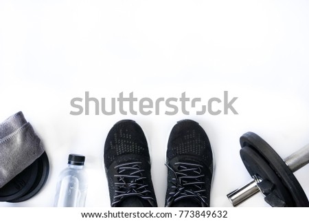 Top view of black tone fitness accessories on white background with copy space, equipment for weight training exercises concept