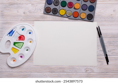 Top View of Blank Canvas with Art Supplies on White Wooden Table - Powered by Shutterstock