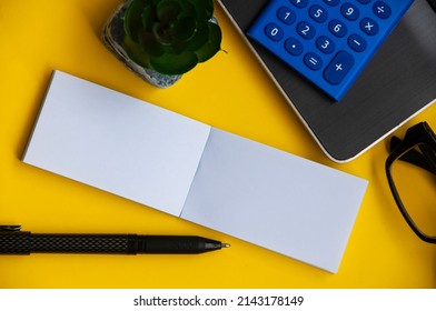 Top View Of Blank Notepad With Office Setting Background. Copy Space