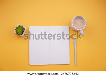 Top view of a blank open notebook with a pen, coffee mug, and succulent plant on vibrant yellow background. Perfect for productivity, planning, creativity, or workspace concepts in minimal style