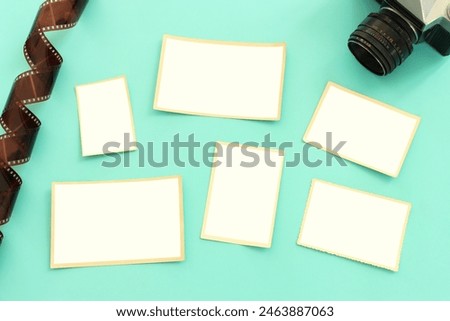 top view of blank photo frames over pastel blue background.