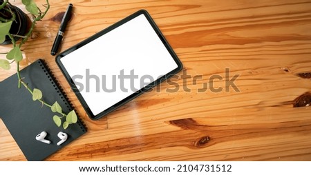 Top view of blank screen tablet on plank board wooden background. Mockup blank screen for product display.