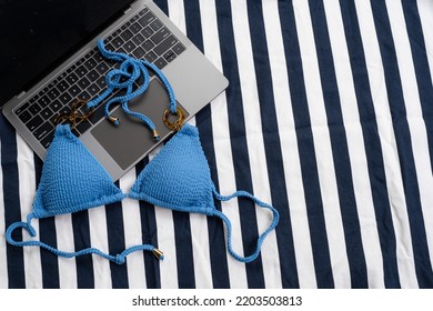 Top View Of Blue Bikini And Laptop On The Beach Blanket For Picnic On The Beach. Summer Vacation, Summer In Holiday Concept. Freelance Concept.