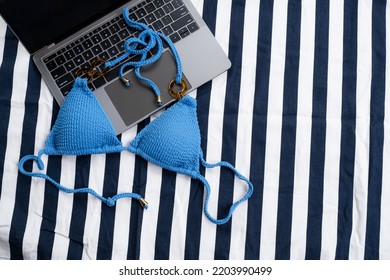 Top View Of Blue Bikini And Laptop On The Beach Blanket For Picnic On The Beach. Summer Vacation, Summer In Holiday Concept. Freelance Concept.