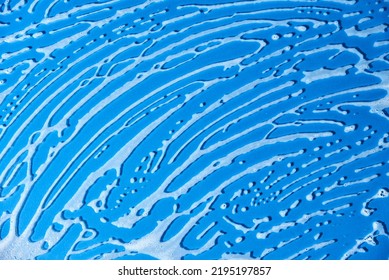 Top View Of A Blue Glass Surface Covered With Soap Foam. Monochromatic Background Without People, Concept Of Cleanliness.