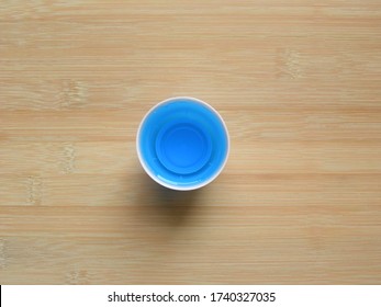 Top View Of Blue Mouthwash Liquid In Round Measuring Cup