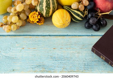 Top View Of Blue, Rustic Wooden Background With Holy Bible And Fall Fruits (pumpkins, Grapes, Apples). The Biblical Concept Of Christian Thanksgiving And Thankfulness To God Jesus Christ. Copy Space.