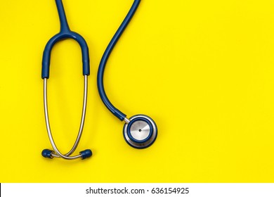 Top View Blue Stethoscope On Yellow Background. For Check Heart Or Health Check Up Concept