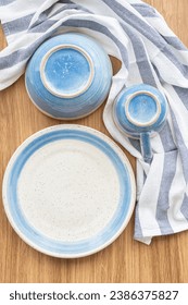 Top view of blue and white dish with upturn bowl and cup,  napkin on wood table, vertical frame