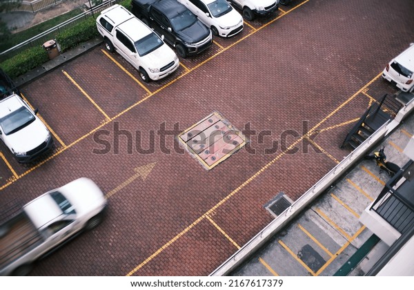 Top view of a blurred pick up truck passes by\
empty car parks.