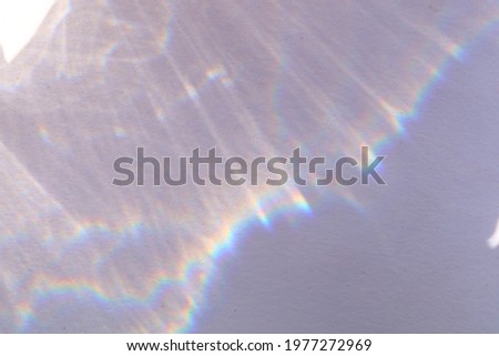Top view of blurred rainbow shadow overlay on paper color background. Minimal summer concept with sun light glares and reflects. Creative copyspace. Flat lay. 