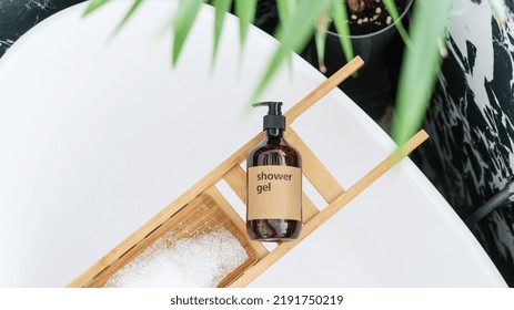 Top View Of Body Cleanser In Brown Bottle And Bath Sea Salt On Bamboo Caddy On Bathtub In Hotel Bathroom, Bodycare Morning Routine Concept