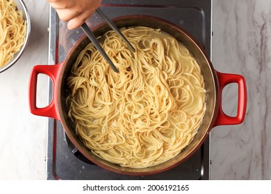 Top View Boiling Korean Instant Noodle Or Spaghetti Pasta  On Red Pan, Home Cooking Activity