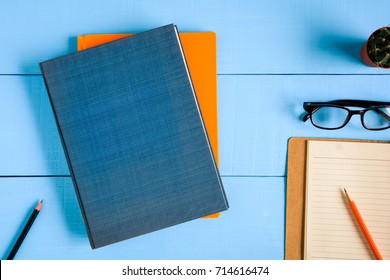 Top View Book Mockup And Pencil Note On Blue Wood Table With Cactus Decoration On Desk