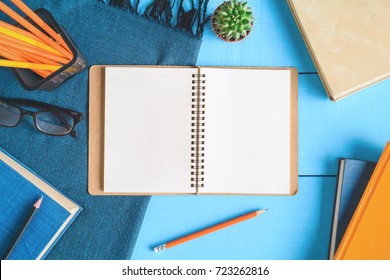 Top View Book And Pencil Note On Blue Wood Table With Cactus Decoration On Desk