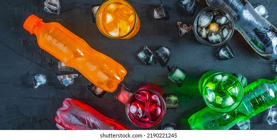 Top view  lot of bottles Soft drinks in colorful and flavorful  on the table, Glasses with sweet drinks with ice cubes