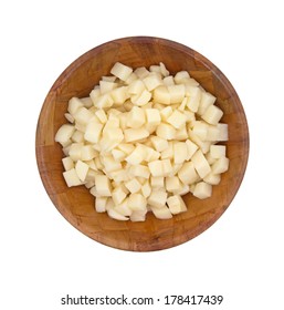 A top view of a bowl of canned, cut and diced white potatoes in a wooden bowl on white.