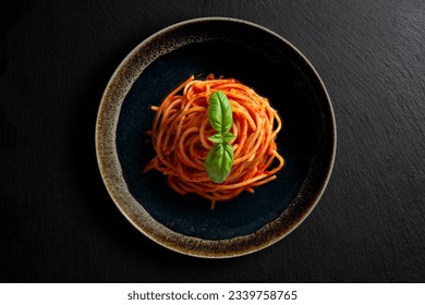 Top view of bowl with spaghetti tomato and basil on black stone - Powered by Shutterstock