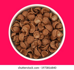 Top View Of Bowl With Sweet Chocolate Cereal Flakes For Breakfast On Red Background