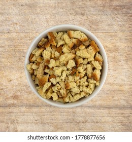 Top View Of A Bowl Of Uncooked Stovetop Stuffing Ingredients Atop An Old Wood Cutting Board.