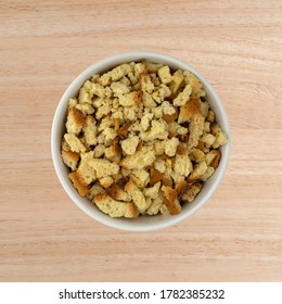 Top View Of A Bowl Of Uncooked Stovetop Stuffing Ingredients Atop A Wood Table.