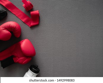 top view of boxing gym concept with boxing glove, Gym Outfit, skipping rope and accessories on yoga mat background. - Powered by Shutterstock