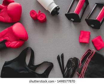 top view of boxing gym concept with boxing glove, Gym Outfit, skipping rope and accessories on yoga mat background. - Powered by Shutterstock