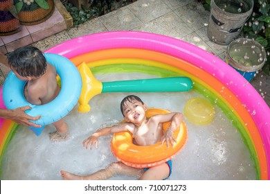 Top View Of Boy Play Water And Turning Face Up In Kiddie Pool . Leisure Activity