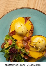 Top View Breakfast Served On Plate - Eggs Benedict With Hollandaise Cheese Sauce, Toast And Fresh Salad. Close Up, Selective Focus, Overhead, Flat Lay