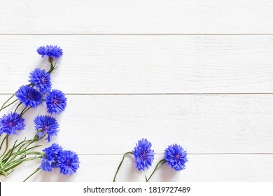 Top View Of Bright Blue Flowers On A Textured White Wooden Background. Floral Flatlay.