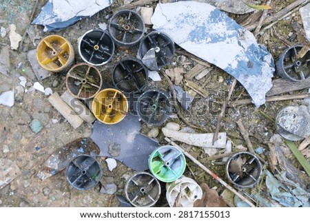 Top view of broken plastic caps and scattered debris on a dirty ground.