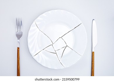 Top view of broken plate on kitchen table. Concept food crisis.
